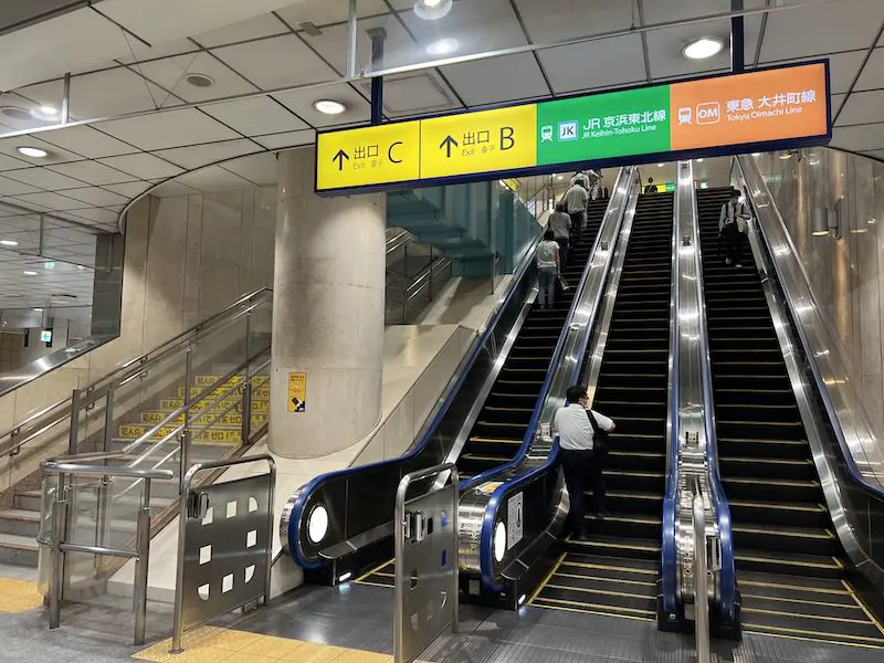 Stairs and escalator from Rinkai Line ticket gate on B1F to Exit B and C