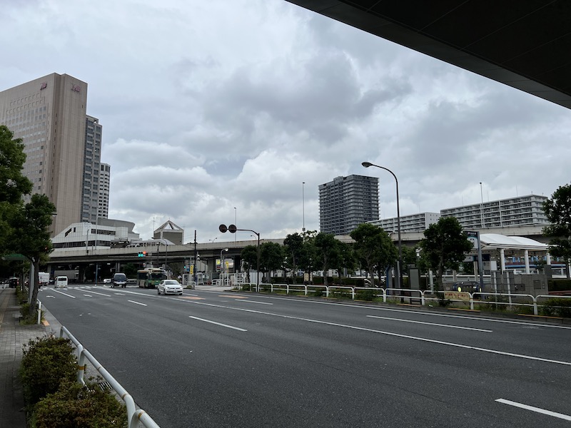 左の信号上にある白い建物が東京モノレールの南口、右側の白いテントがりんかい線のA出口。
