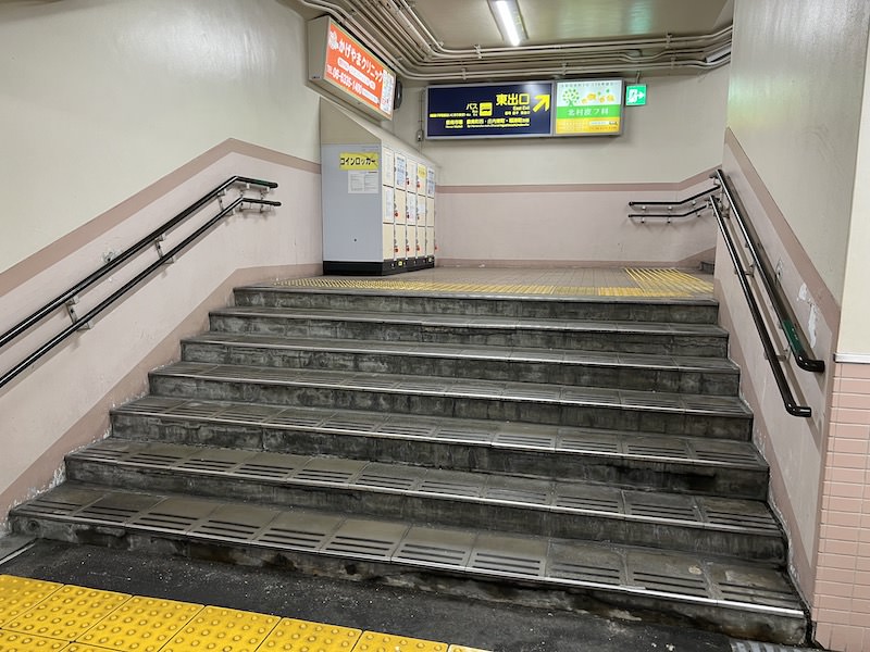 東出口への階段の踊り場にコインロッカーがある
