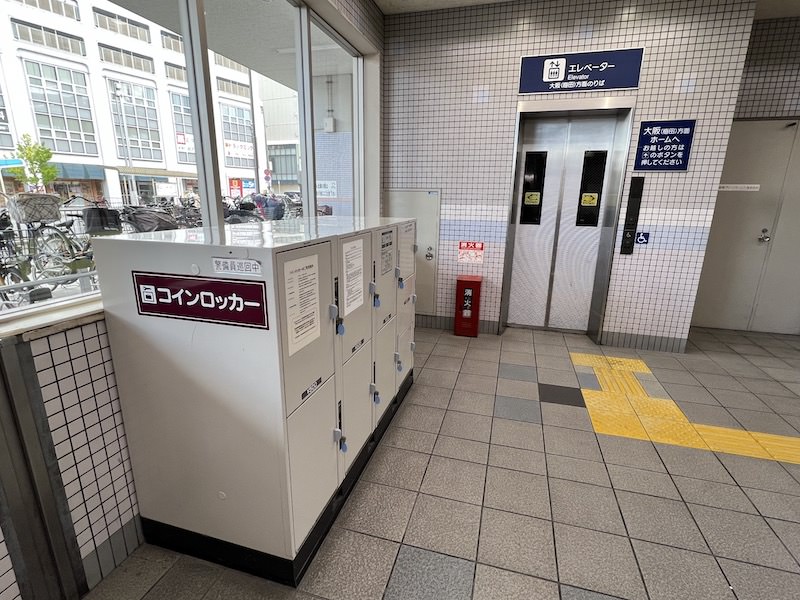 大阪梅田方面行きホームへのエレベーター前にあるコインロッカー(写真の背後に上り下りのエスカレーターがある)