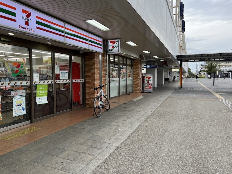 コンビニの先に「コインロッカー」の案内表示が見える。奥は近鉄天理駅。