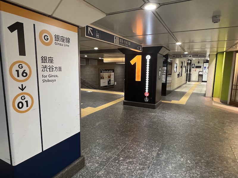 銀座・渋谷方面行きホームへの階段横にトイレへの通路がある