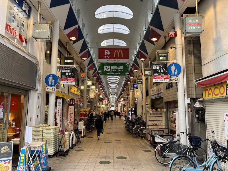 「駒川商店街」「長居公園」方面へつながる「針中野駅前通り」。長居公園へは750mで意外と遠い。