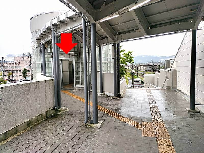 通路左側のエレベーターのりばからエレベータに乗り、1階へ降ります。